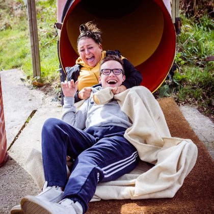 Two people going down the slide